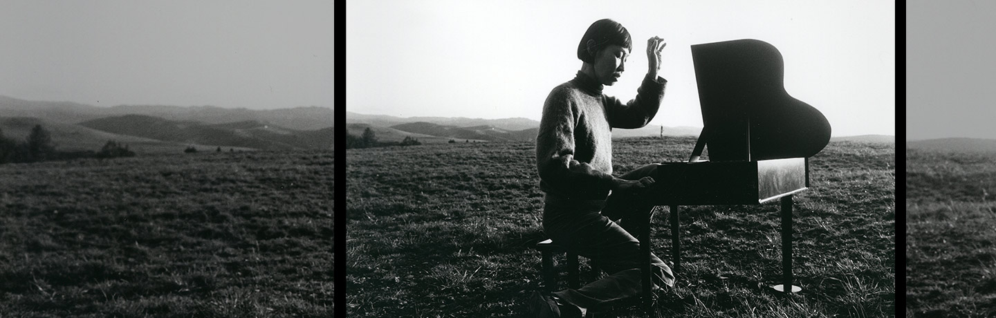 Margaret Leng Tan seated at toy piano in meadow